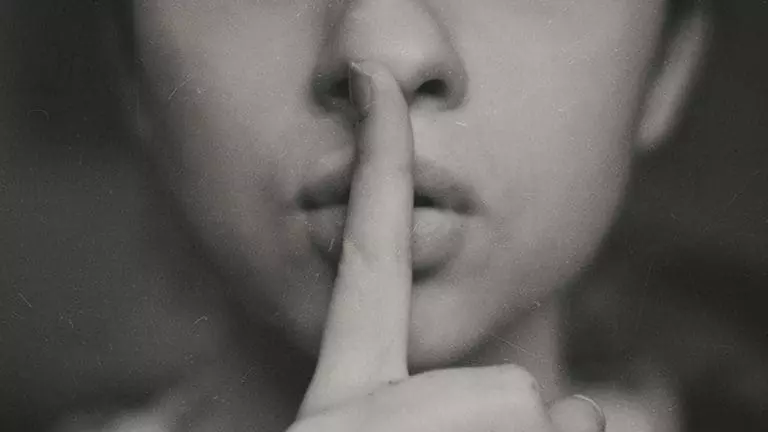 grayscale photo of woman doing silent hand sign