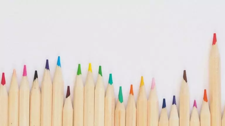 colored pencil lined up on top of white surface