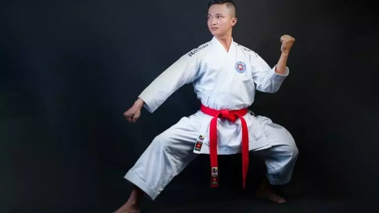man standing wearing white karate gi