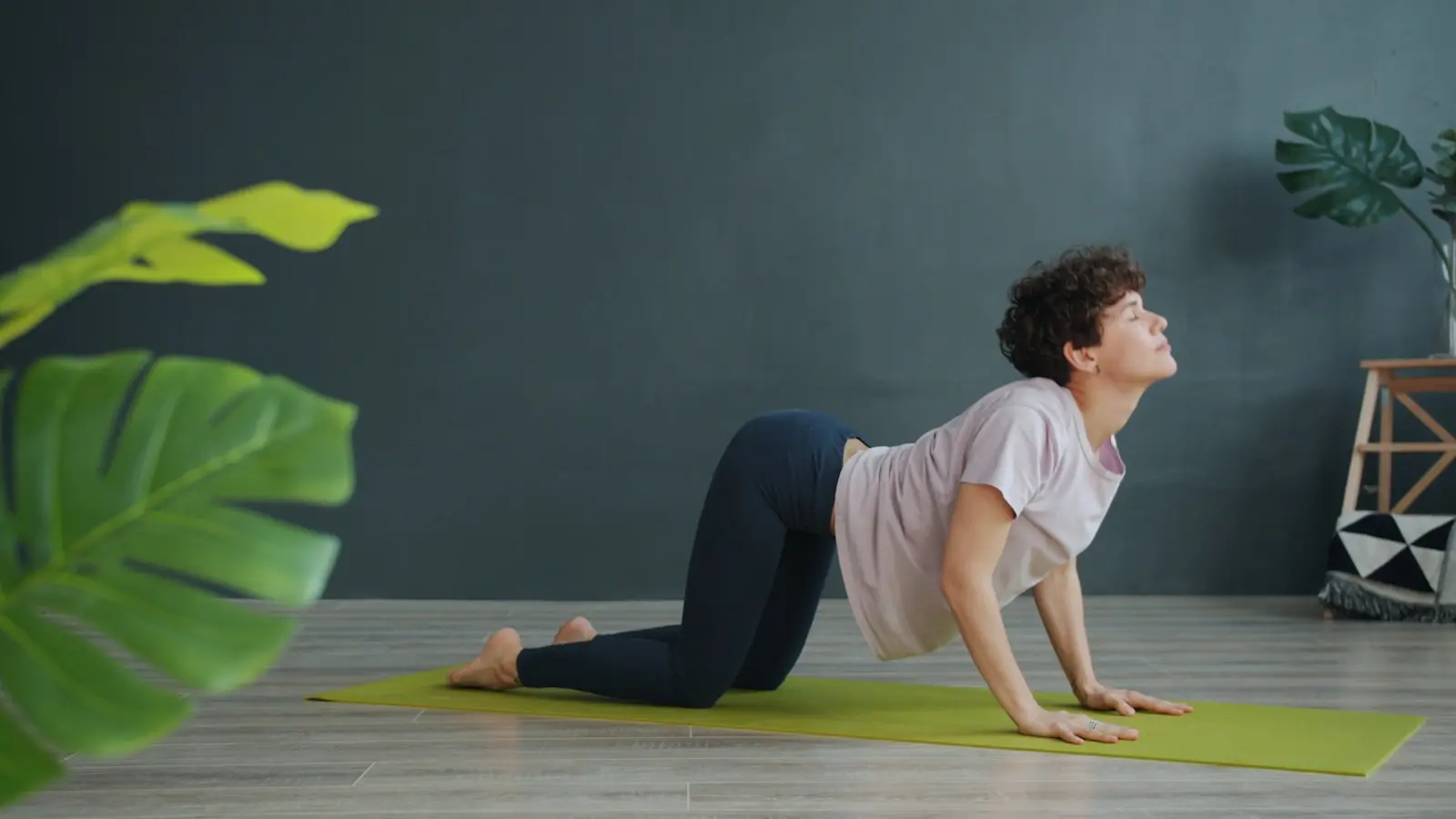 Woman in yoga pose on mat indoors