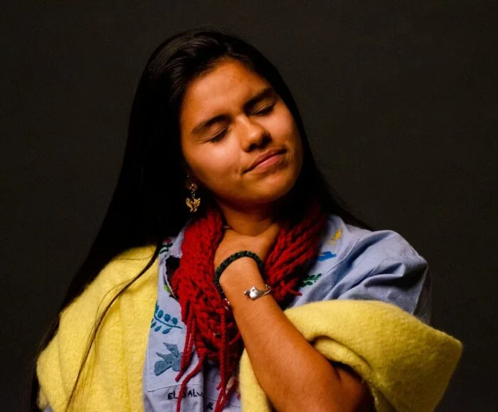 a woman wearing a yellow scarf and a red scarf around her neck